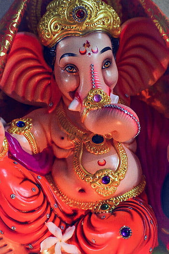 Ganesh Festival, colorful Ganesh idol, detailed craftsmanship, cultural symbolism, Ganesh masks, ornate jewelry, religious art, Hindu deity, festive decoration, traditional art, elephant god