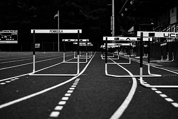 grayscale photo, hurdles, sports field, monochrome image, empty sports track, athletic themes, track and field, black and white, running track, hurdle race, sports equipment