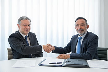 businessmen shaking hands, suits, office table, documents, professional meeting, handshake, business agreement, formal attire, office setting, business partnership, corporate deal