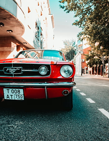 Red Ford Mustang, classic car, sunny urban street, classic architecture, vintage vehicle, Mustang, automotive photography, red car, street photography, iconic car, vintage Mustang