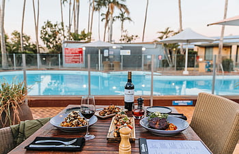 Italian food, dining table, restaurant, poolside, assorted dishes, red wine, outdoor dining, Italian meal, pool view, restaurant setting, dining experience