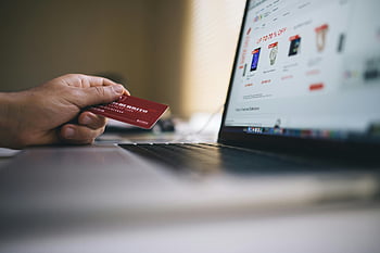 E -Commerce -Transaktionen, Online Einkaufen, Kreditkarte, Laptop-Computer, Fotografie mit selektivem Fokus, Red Smart Card, schwarzer und grauer Laptop, Person, die Karte hält, E-Commerce, Onlinebezahlung