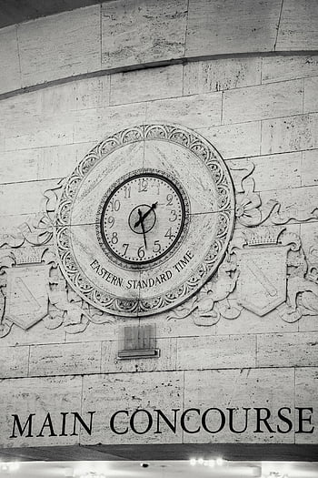 black and white, vintage clock, historic main concourse, Eastern Standard Time, stone wall, main concourse, engraved emblem, clock engraving, historic clock, black and white image, stone wall clock