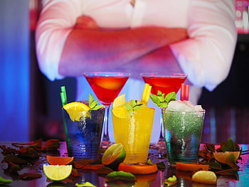 colorful cocktails, citrus slices, bar setting, nightlife, wine glass, drinking glass, selective blur, bartender, vibrant drinks, garnished cocktails, bar scene