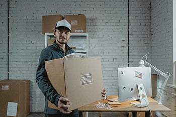 Muž v bundě, Držení kartonové krabice, kurýr, moderní kancelář, Profesionální doručovací služba, uvnitř, Velká kartonová krabice, poslíček, Nastavení kanceláře, Vnitřní dodávka, Profesionální kurýr