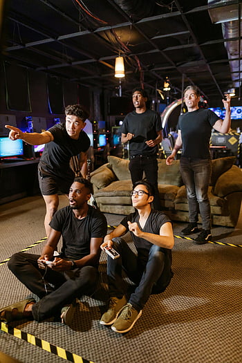 friends playing video game, arcade setting, young adults gaming, teamwork, technology, group fun, video game controllers, casual gaming, indoor arcade, gaming friends, arcade environment