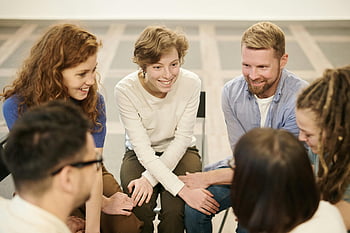 people sitting indoors, diverse group, smiling, collaborating, team meeting, teamwork, cooperation, indoor setting, group interaction, professional environment, casual meeting