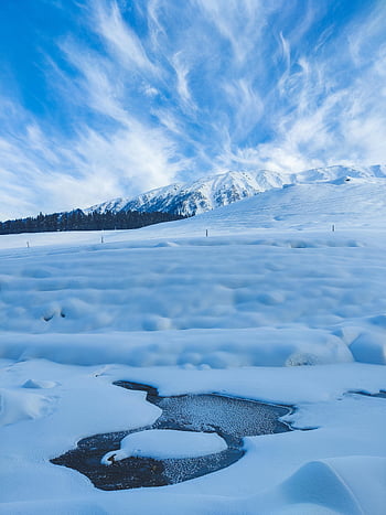 frozen river, mountainous area, snowy mountain, bright blue sky, winter scene, snow-covered landscape, mountain view, frozen water, winter landscape, snow, blue sky