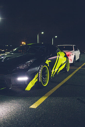 sports car, neon-highlighted, city parking lot, night, fast-paced, modern vibe, headlights, black car, vibrant, neon, wheels