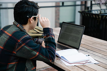 Muž, který čte notebook, Venkovní studium, moderní učení, Studium studenta, Notebook notebook, Venkovní stůl, vzdělávací prostředí, zaměřený student, vzdělávací technologie, studijní relace, příležitostné učení