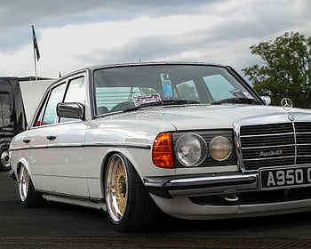 white Mercedes Benz, classic vintage car, custom rims, parked outdoors, iconic automotive design, green tree, white car, Mercedes car, vintage Mercedes, outdoor parking, classic car