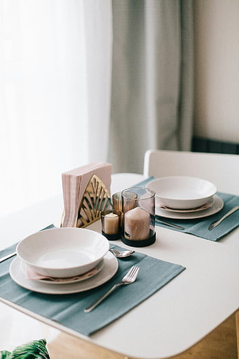 service de vaisselle blanche, réglage de table minimaliste, vaisselle élégante, serviettes, bougies, ambiance douce, ambiance légère, réglage de la table, assiettes blanches, table à manger, décor de table