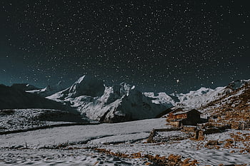 snow-covered landscape, starry night, rustic cabin, snow-capped mountains, winter scenery, mountain cabin, night sky, snowy terrain, alpine view, rural winter, mountain retreat