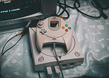 Sega Dreamcast, console, controller, CRT monitor, retro gaming, vintage setup, close-up, JVC, gaming setup, multi-word terms, photo keywords