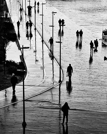 rainy day, seaside promenade, Istanbul, street photography, people walking, rainy weather, waterfront, urban scene, black and white, reflections, umbrellas
