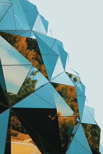 геометрична отразяваща фасада, футуристична сграда, геометрични модели, отразяваща повърхност, модерна архитектура, дърво отражение, размисъл на небето, архитектурен дизайн, стъклена фасада, градски пейзаж, съвременна сграда