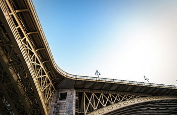 beige metal bridge, low angle view, modern steel bridge, clear blue sky, bridge structure, steel bridge, bridge architecture, bridge design, bridge engineering, bridge photography, bridge construction