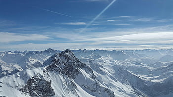 bird's eye view, snow-covered mountains, mountain peaks, clear blue sky, winter landscape, stunning view, snow coated mountains, alpine scenery, high altitude, mountain range, winter season