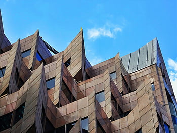 未来的な建築、 灰色の尖塔のある建物、 鋭角、 印象的なファサード、 澄んだ青い空、 モダンデザイン、 建築デザイン、 ユニークな建物、 現代建築、 都市のスカイライン、 革新的なデザイン