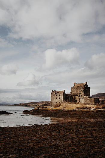 Eilean Donan Castle, Scotland, cloudy day, coastline, autumn, Scottish landmark, picturesque view, historic castle, natural scenery, overcast sky, water landscape