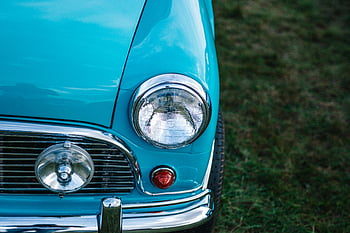 vintage car, teal car, round headlight, chrome details, close-up, outdoors, nostalgic style, blue car, classic car, retro vehicle, automotive design