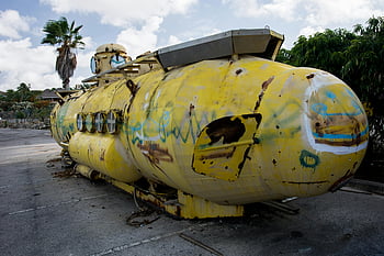 U-Boot, grauer Bürgersteig, Stadtgebiet, Palmen, Graffiti, draussen, altes U-Boot, gelb und grau, U-Boot mit Graffiti, städtischen Umfeld, Outdoor -Display