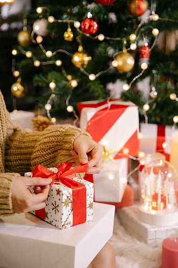 Christmas gift wrapping, decorated Christmas tree, holiday celebrations, cozy scene, gift wrapping, Christmas presents, festive atmosphere, Christmas decorations, holiday season, gift preparation, Christmas tree lights