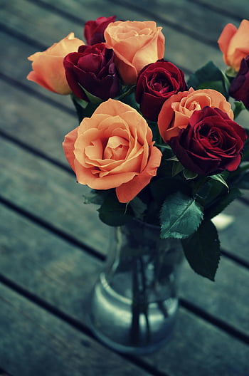 red roses, orange roses, clear glass vase, wooden table, bouquet, floral arrangement, background image, vibrant flowers, romantic flowers, decorative flowers, natural beauty