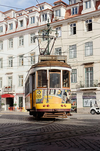Lisbon street electric train, vintage tram, heart of Lisbon, Portuguese urban life, Lisbon Portugal, electric train, vintage tramway, urban transport, cityscape, tram route, cobblestone street