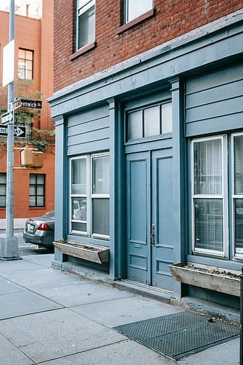 blue door, residential building, city street, urban architecture, building entrance, street corner, brick building, window, sidewalk, street sign, blue building