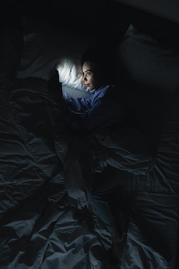 im Bett, mit Smartphone, Nachtzeit, Bildschirm Licht, hinlegen, Bettlaken, Dunkelkammer, entspannt, Nachtaktivität, Mobiltelefon, Bettruhe