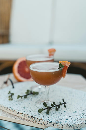 cocktail drinks, grapefruit cocktails, elegantly garnished, modern terrazzo table, refreshing drink setup, terrazzo table, grapefruit garnish, cocktail setup, modern table, drink presentation, cocktail presentation