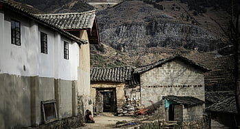 village near mountain cliff, old rustic house, rural village, mountainous backdrop, traditional architecture, stone buildings, tiled roofs, countryside scenery, remote village, natural landscape, mountain view