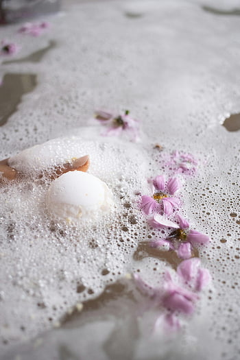 bath bomb, pink flowers, foamy bubbles, serene spa, bath salt, relaxing atmosphere, spa bath, water surface, bath scene, white ball, floral bath
