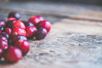 cranberries, red cranberries, wooden surface, rustic view, close-up photo, vibrant red, scattered cranberries, cranberry photo, cranberry image, cranberry close-up, cranberry rustic