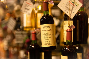 Bordeaux -wijn, Groene met het label fles, diepte fotografie, detailopname, slijterij, prijskaartjes, wijnflessen, hangende flessen, Wineaux, wijnetiket, wijnwinkel