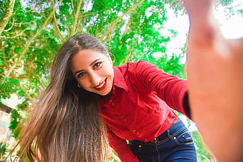 usmívající se žena, červené tričko, modré džíny, s selfie, Zelený strom, park, Světlý letní den, radost, relaxace, venkovní, selfie