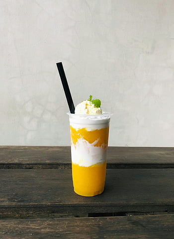 Mango saft, beschwingt, Sahne, Stroh, Erfrischendes Getränk, Nahansicht, Minze, Eis, gelbe Getränk, Holztisch, schwarzer Stroh