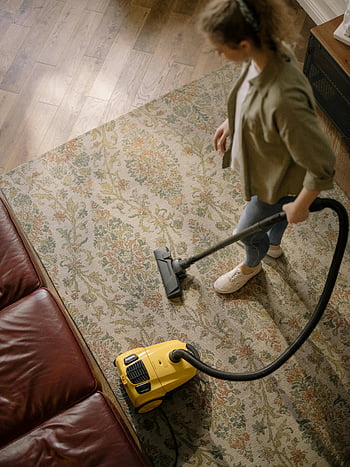 woman vacuuming, yellow and black vacuum cleaner, carpet cleaning, housekeeping, overhead view, home cleaning, vacuum cleaner, cleanliness, indoor cleaning, living room, vacuuming carpet