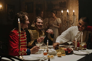 Britské vojenské kostýmy, muži v kostýmech, historická večeře, bohatá hostina, Scénní scéna, dobové kostýmy, Elegantní večeře, Historické prostředí, muži si užívají hostinu, večeře při svíčkách, historická rekonstrukce