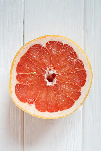 grapefruit, close-up, sliced grapefruit, vibrant segments, juicy segments, white wooden background, grapefruit half, citrus fruit, healthy food, fruit photography, food photography