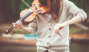 woman, gray cardigan, playing violin, daytime, close-up, violinist, outdoors, warm tones, live music, music performance, natural light
