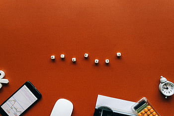 orange background, white letter blocks, financial tools, creative still life, markets word, stock market, mobile phone, alarm clock, pills container, office supplies, desk setup