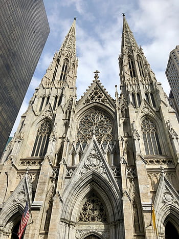 St. Patrick's Cathedral, New York City, Manhattan, Gothic architecture, cathedral spires, religious building, urban landmark, American flag, stained glass window, historic church, cityscape background