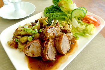 pork tenderloin, rosemary garnish, roasted potatoes, fresh salad, delicious meat dish, plate presentation, food photography, culinary art, meal serving, restaurant dish, healthy eating
