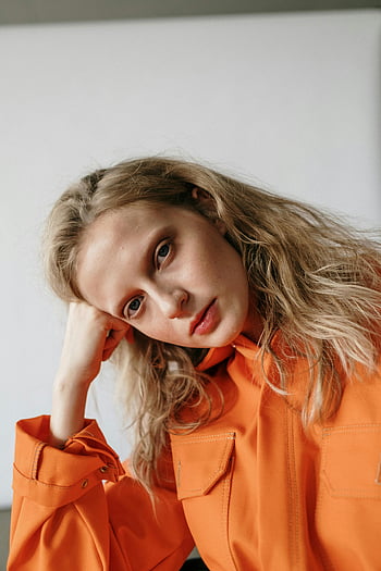 kobieta w pomarańczowej, długie rękawy, ręka na głowę, blond włosy, Kontemplacyjna pozy, białe tło, pomarańczowa koszula, portret, fotografia mody, studio strzał, modelka