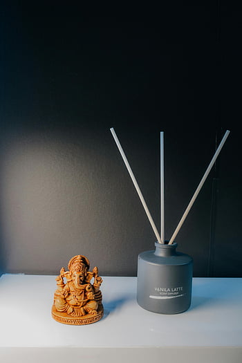 ganesh figura, aroma diffúzor, csendélet, hindu istenség, asztali elrendezés, nyugtató jelenet, Illat diffúzor, vanília latte, díszítő elemek, beltéri dekoráció, lelki szimbólum