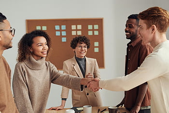 diverse group, colleagues, shaking hands, productive office meeting, white wall, office setting, professional interaction, teamwork, business meeting, collaboration, multi-ethnic group