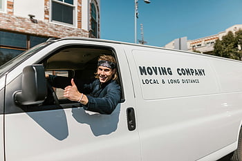 moving company, van, mover, thumbs up, smiling, local and long distance, white van, black jacket, outdoor, parked, building background