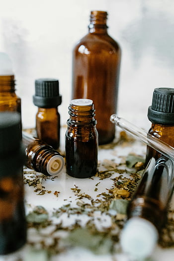 eteriska oljeflaskor, gula flaskor, naturlig helande, närbild fotografi, selektiv fokusering, eteriska oljor, naturliga egenskaper, aromaterapi, naturläkemedel, alternativ medicin, hälsa och välmående